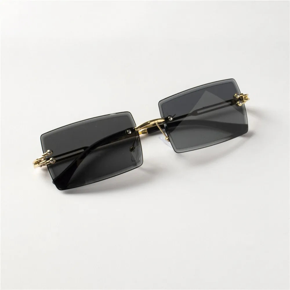 Lunettes de soleil tendance Berlin style rectangulaire avec verres sombres et monture dorée élégante